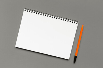 Mockup. Clean white sheet of paper and orange pen on Gray background. Notebook for notes. Demonstrating color of 2026 year, Cloud, Dancer