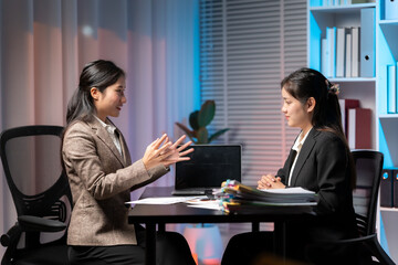 Business Interaction: Two professionals engaged in a focused business discussion in an office setting, possibly a meeting, interview, or client consultation, the scene is illuminated by soft lighting.