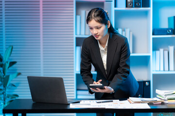 Businesswoman at work: A focused businesswoman, impeccably dressed, navigates her workspace with a blend of confidence and precision. Lit with cool hues.