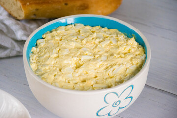 Appetizing and spicy salad with egg and processed cheese in a salad bowl.