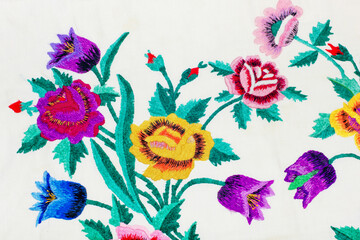 Colorful floral embroidery on cotton fabric with floral patterns on a white background.