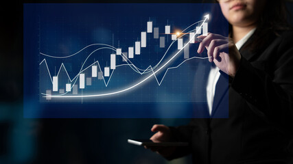 A business professional examines stock market trends by interacting with digital graphs and data in...