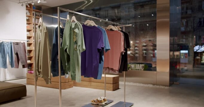 Clothing and shoes in a board shop. Skateboards and sneakers on display. Retail space. Sales, shopping. Consumerism, modern lifestyle. Window shopping. Merchandise presentation.