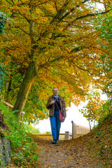 Woman walking in Park near Salzburg in Austria during autumn season looking toward the camera
