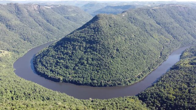 Drone footage of Gelain viewpoint showing the horseshoe bend of Rio das Antas on a bright sunny day, scenic natural landscape in Flores da Cunha, Serra Gaucha, Brazil