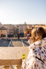 Woman taking a photo during New Year celebration overlooking Rome near the Spanish Steps. Festive winter tourism, holiday travel, city break, freedom, inspiration and European lifestyle concept