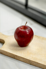 Food photography of fresh red apples on a wooden cutting board.