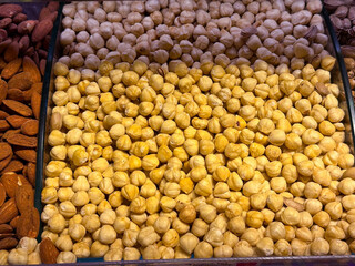 Peeled hazelnuts densely packed in a market display in Istanbul bazaar. Natural nut ingredients, wholesome nutrition, and everyday food abundance emphasized through repetition and form.