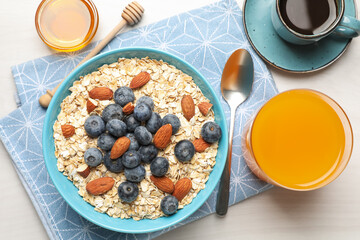 Dry oat flakes, nuts and blueberries served on grey wooden table for breakfast, flat lay