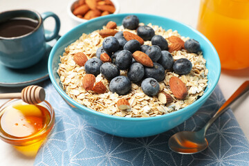 Dry oat flakes, nuts and blueberries on grey table for breakfast, closeup