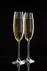 Flute glasses with sparkling wine on black background. Merry Christmas and Happy New Year