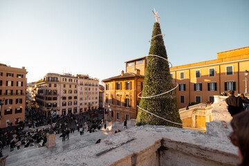 Festive city square in Rome near the Spanish Steps with a decorated Christmas tree and warm winter light. Holiday atmosphere, winter tourism, city break travel, celebration, joy and European lifestyle