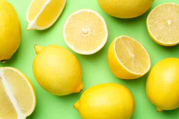 Fresh ripe lemons on light green background, flat lay