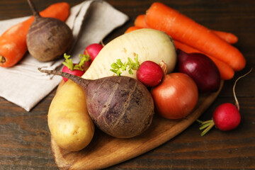 Different raw vegetables on wooden table, closeup