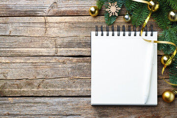 New Year aims. Blank planner, pen and festive decor on wooden table, flat lay. Space for text