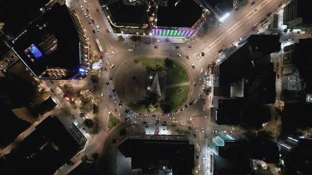 Aerial top down view of night traffic on a circular road in Metaxourgio district, Athens, Greece. Cars moving in light trails create an urban city pattern