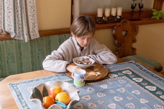 Boy eating breakfast in cozy kitchen setting
