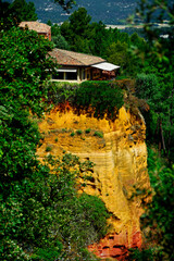 Fototapeta premium dom na klifie, dom na ochrowej, zółtej skale, Roussillon, Provence in France, house on the cliff, house on ocher yellow rock,