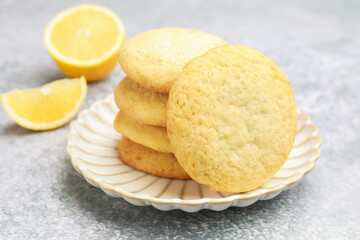 Tasty lemon cookies and fruit slices on grey table, closeup