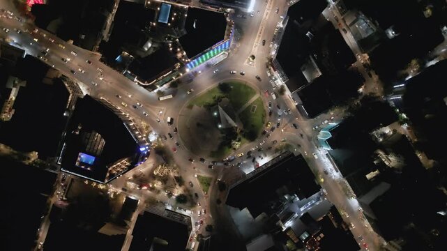 Aerial top down view of night traffic on a circular road in Metaxourgio district, Athens, Greece. Cars moving in light trails create an urban city pattern
