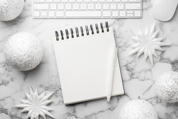 New Year aims. Blank planner, pen and festive decor on white marble table, flat lay