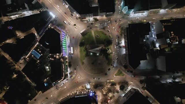 Aerial top down view of night traffic on a circular road in Metaxourgio district, Athens, Greece. Cars moving in light trails create an urban city pattern