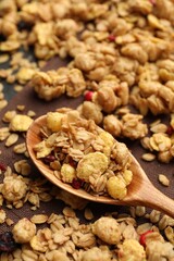 Tasty granola with dried fruits and spoon on table, closeup