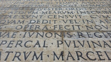 Rome, Italy - 12 January 2025. Detail from the Res Gestae wall at the Ara Pacis showing crisp Latin inscriptions across stacked stone slabs.