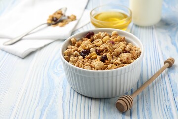 Tasty granola with dried fruits in light blue wooden table, closeup