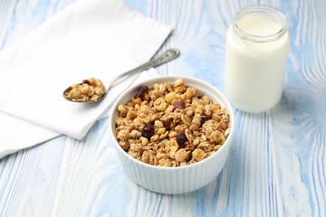Tasty granola with dried fruits and milk in light blue wooden table