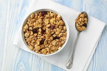 Tasty granola with dried fruits in light blue wooden table, top view