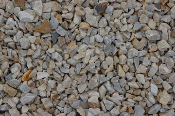 Close-up view of various small gravel stones in shades of gray and brown, showcasing natural textures and colors, ideal for landscaping and construction projects
