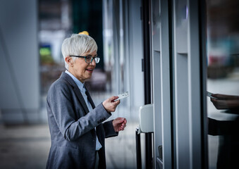 Woman using card at building entrance