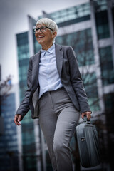 Businesswoman walking with briefcase in city