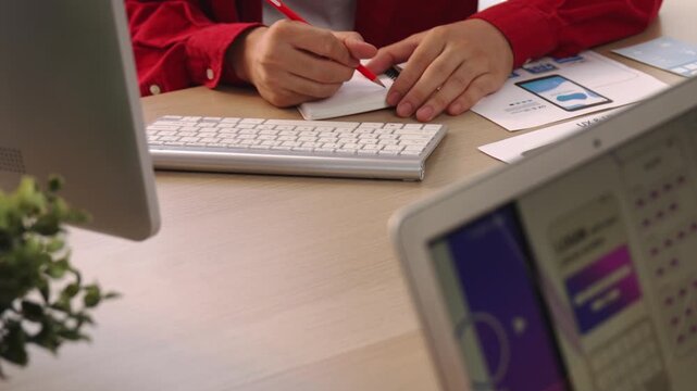 Startup company employee planning for user interface prototype for mobile application or website in office with model of program on desk. UX UI designer consider user friendly interface plan. Synergic