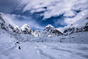 Trekking route to Lobuche after snowfall. Lingtren and Khumbutse peaks behind snowy valley. Everest base camp trekking, Nepal.