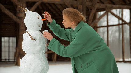 Woman Making a Snowman in Winter
