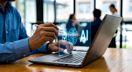 Business person uses a stylus on a laptop with a holographic artificial intelligence symbol.