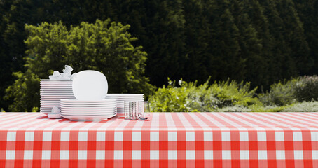 Empty red and white checkered tablecloth for picnic over green background 