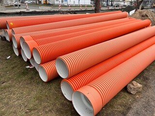 Bright orange pipes intended for road maintenance and infrastructure projects, ensuring durability, visibility, and reliable performance.