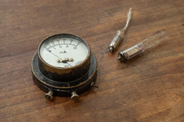A vintage arrow voltmeter is lying on the table.An old device for measuring current strength.Voltmeter is a milliammeter.