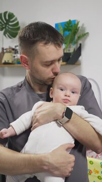 Father holding gently tiny newborn boy in his hands. Daddy showing affection to baby. Gental parenting and family love atmosphere concept. dad share a tender parenting moment playing with newborn