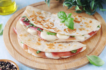 Traditional Italian dish Piadina romagnola - flat bread with mozarella and proscuitto	
