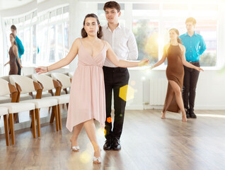 Fototapeta premium Happy girls paired with guys dance waltz in dance class