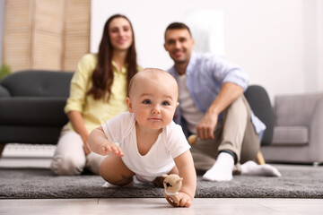 Fototapeta premium Happy parents with their cute baby at home, selective focus