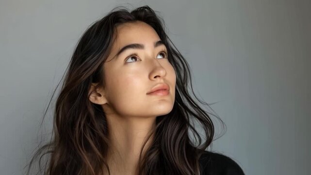 A girl with long hair gazes thoughtfully into the distance, creating an image of dreaminess that would fit perfectly into the design of a music album cover as the main background.
