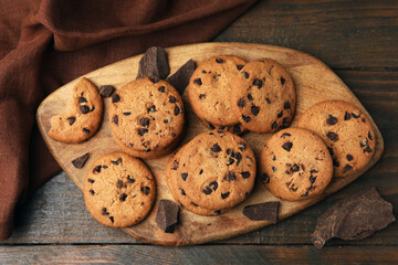 Delicious chocolate chip cookies on wooden table, top view