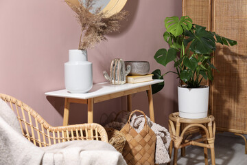 Monstera houseplant and stylish furniture with decor at home