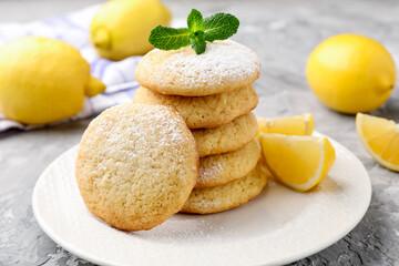 Tasty lemon cookies and fruit slices on grey table, closeup