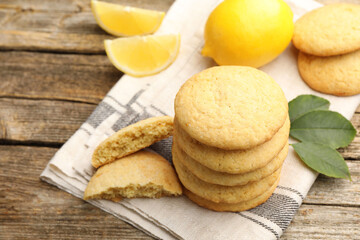 Tasty lemon cookies and fruit slices on wooden table, closeup